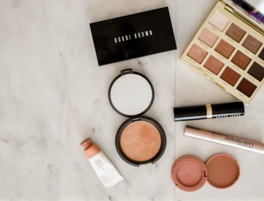 photo of assorted makeup products on gray surface