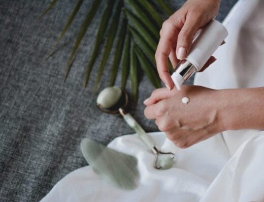 person holding white plastic bottle pouring white liquid on white ceramic mug